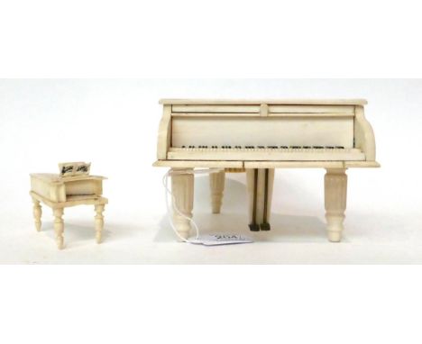 * An ivory cased musical box, early 20th century, in the form of a grand piano, 15cm long; and a similar miniature model of a