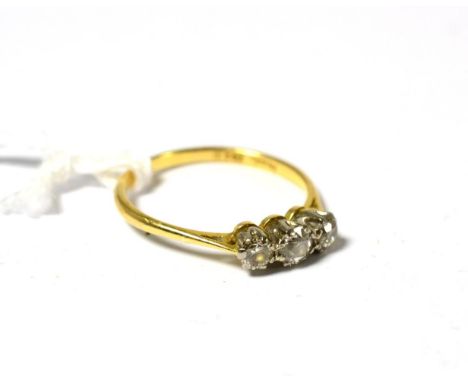 A diamond three stone ring, three graduated diamonds in white claw settings on a yellow tapered shoulder plain polished shank