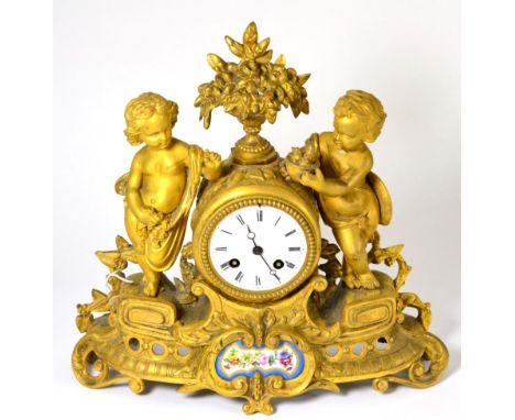 An ormolu and porcelain mounted striking mantel clock, circa 1890, floral urn flanked by two infants, porcelain floral panel,