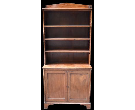 A Regency mahogany bookcase with arched pediment top, above adjustable shelves and tow cupboard doors, raised on bracket feet