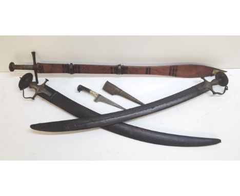 A group of Indian and Middle Eastern style decorated swords and a dagger to include a pair of Mughal style carved swords 