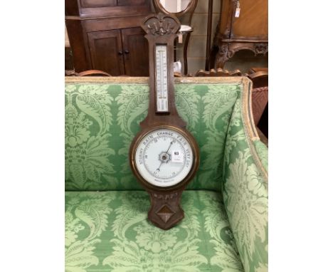 A late Victorian oak aneroid barometer and thermometer, height 78cm Length of thermometer box: 26cm