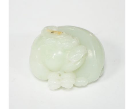 A Chinese celadon jade carving of a lion-dog, in recumbent pose, its crest with a russet inclusion, 5.3cm No damage seen.