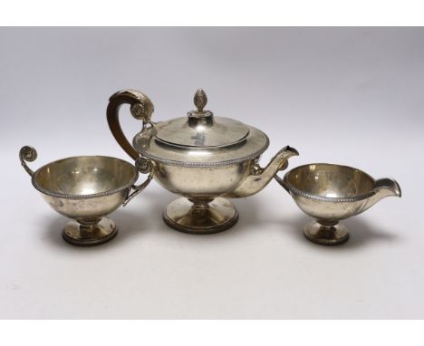 A 1930's silver circular pedestal three piece tea set, Goldsmiths &amp; Silversmiths Co Ltd, London, Sheffield, 1933, sugar b