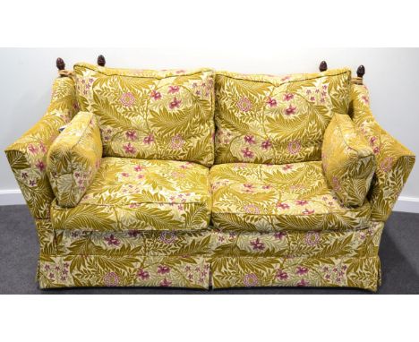 A Feather-Filled Knole Style Sofa of recent date, upholstered in gold leaf pink floral design fabric, the drop ends above fou