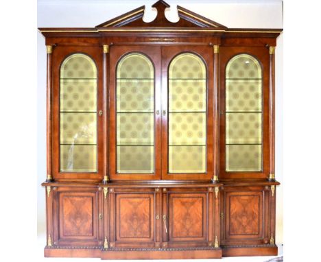 A Good Quality Reproduction Walnut and Gilt Metal Mounted Four Door Library Bookcase in the Regency style, with an architectu