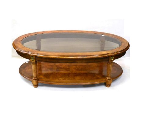 A Reproduction Walnut Oval Coffee Table, with bevelled glass plate, reeded tapering supports joined by a parquetry decorated 