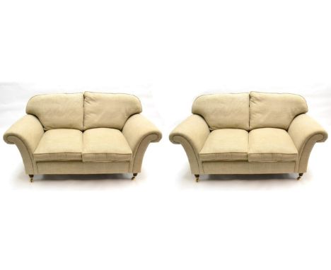 A Pair of Laura Ashley Sofas, upholstered in beige fabric, comprising three-seater sofa with four squab cushions and rounded 