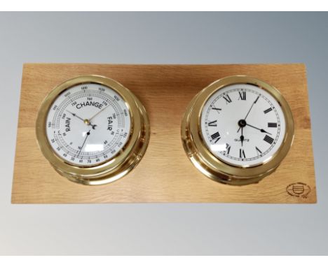 A brass cased ships style barometer and clock mounted on oak board, width 50 cm 