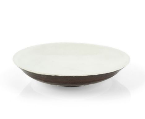 Lucie Rie (1902-1995) Dish with oatmeal glaze and manganese underside impressed potter' seal 14cm diameter.