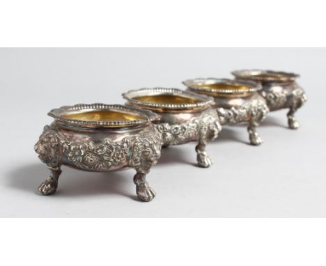 A SET OF FOUR VICTORIAN CASTE SILVER CIRCULAT SALTS with lion masks, claw and ball feet,3ins diameter, London, 1891, maker: G