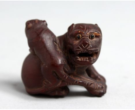 A JAPANESE CARVED WOOD NETSUKE OF TWO DOGS