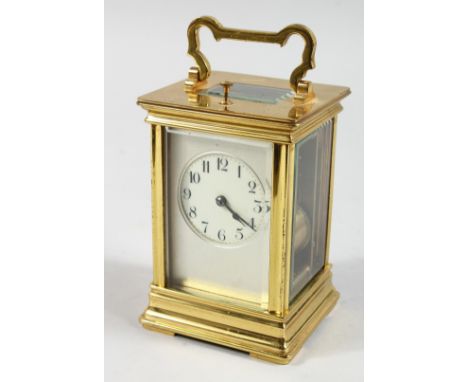 A FRENCH BRASS CARRIAGE CLOCK with eight day movement, striking on a gong, with cream enamel dial on a matted silvered ground