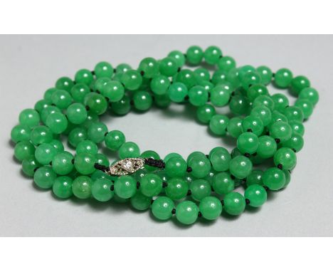 A STRING OF JADE BEADS WITH GOLD AND DIAMOND CLASP, 46ins long.