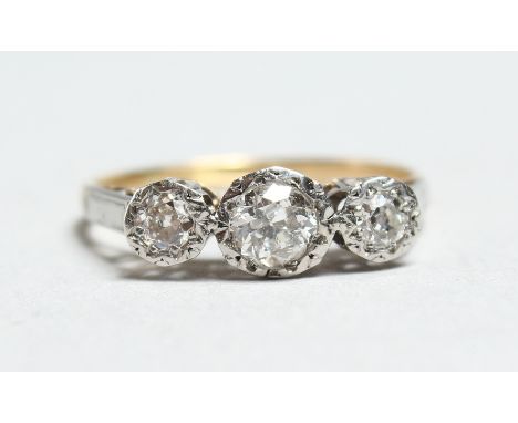 AN 18CT GOLD THREE STONE DIAMOND RING.