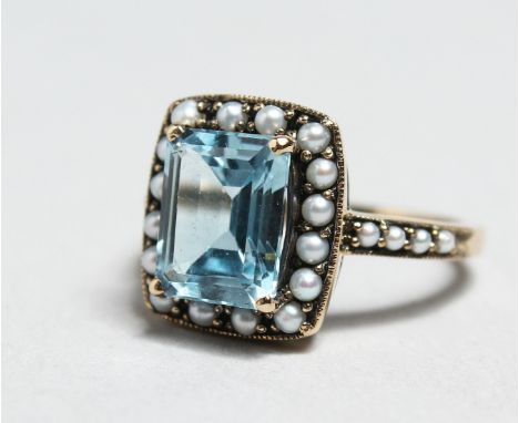 A SILVER, BLUE TOPAZ AND PEARL RING.