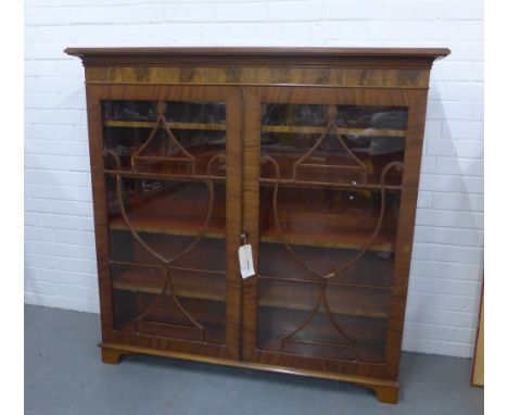 Mahogany bookcase, the rectangular top over a pair of urn astragal glazed doors with a shelved interior, on bracket feet, 133