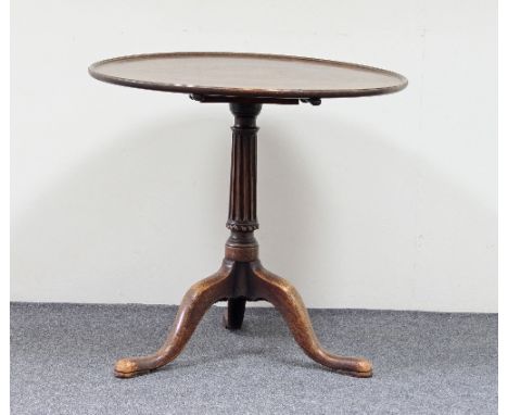 A Georgian mahogany supper table, the dished top on a fluted column support and tripod base, 75cm diameter