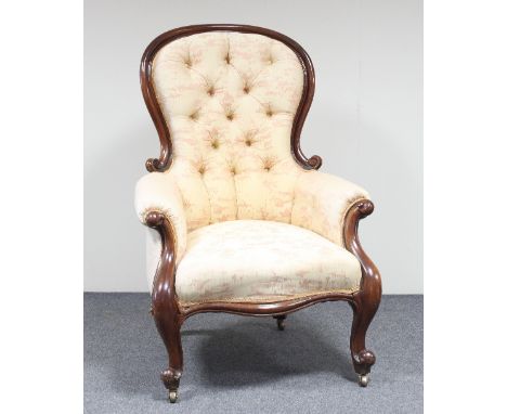 A carved walnut framed armchair with button upholstered back, serpentine seat and scroll carved supports on knurl feet with c