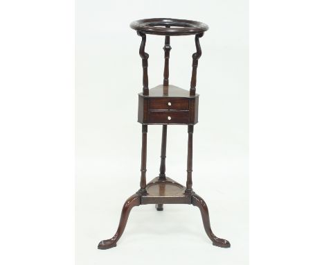 A George III mahogany washstand, with circular aperture for a bowl above a triangular two-drawer tier, on a tripod base, 80cm
