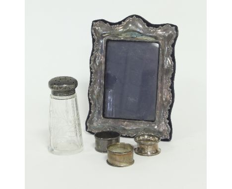 A modern silver photograph frame of scrolling outline with easel back, to take a photograph 13.5cm x 9.5cm, a caster with sil