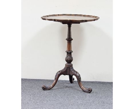 A George III style mahogany tripod table with piecrust edge on carved turned column and carved moulded legs with scroll feet,