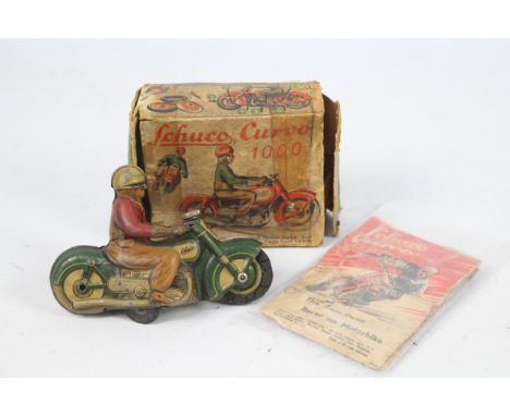 Schuco - A rare 1950s Schuco Curvo 1000 Dare Devil Racer On Motorbike. This green motorcycle shows signs of age and use and w
