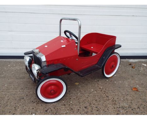 Vintage style pedal car in red. Item has the fleur de lis emblem embossed in metal and a reg of 1938. 12" x 32" height and wi