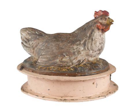 EARLY 20TH CENTURY A FOLK ART CHICKEN EGG DISPENSERof oval form with a pink base, the front with an exit hold with a metal sc