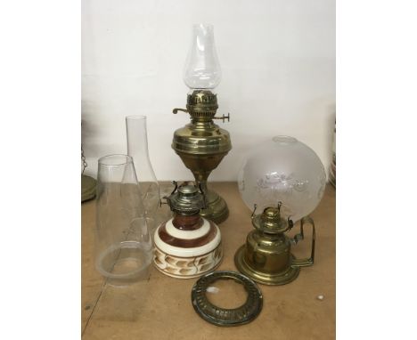 A brass oil lamp with shade and assorted parts