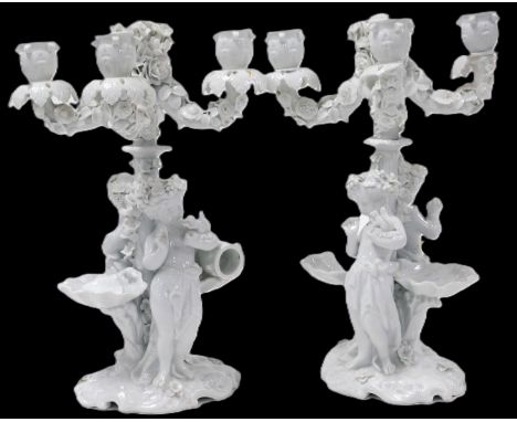 A pair of late 19thC Meissen white glazed porcelain four branch candelabra, encrusted with flowers, raised on a floral encrus