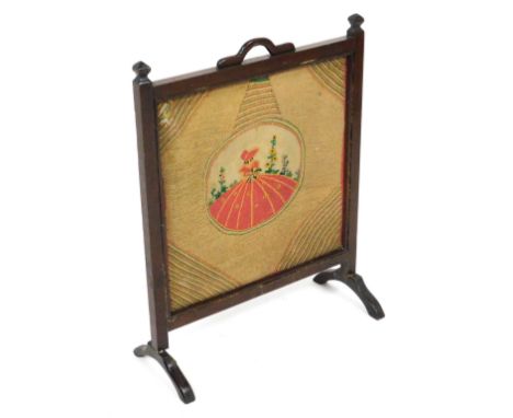 An early 20thC oak fire screen, with a square woolwork tapestry, stitched centrally with a dainty lady, 73cm x 56.5cm.