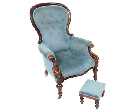A Victorian mahogany balloon back armchair, upholstered in button back light blue draylon raised on turned legs, brass capped