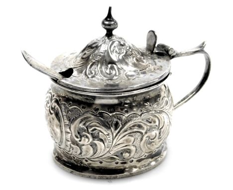 A Victorian silver mustard, with hammered foliate scroll decoration, with blue glass liner, and later caddy spoon, John Millw