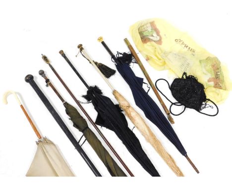 A group of Victorian and later parasols and umbrellas, together with an ebony walking stick, 99cm long, and a scarf showing a
