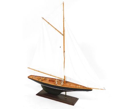 A wooden scale model of a racing yacht, rigged and in full sail, raised on a wooden stand, 100cm high. 