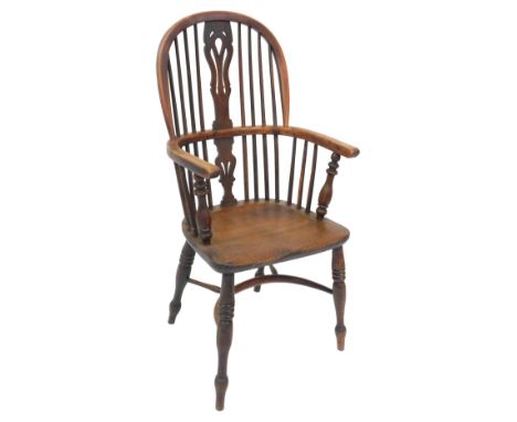 A 19thC yew and elm stick back Windsor chair, with a carved splat, solid saddle seat, raised on turned legs united by a crino