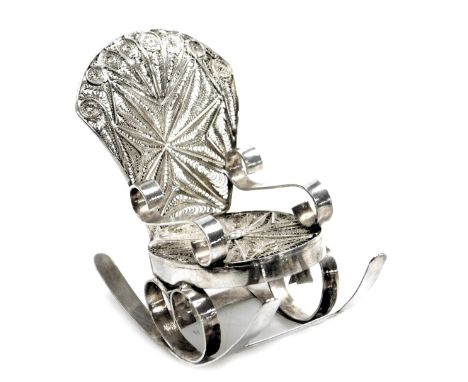 A Continental white metal miniature rocking chair, with filigree scroll patterning, on stout base, maker F G K, 1.24oz. 