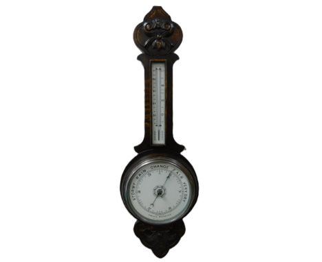 A Victorian oak cased aneroid barometer, with thermometer, the case with foliate carving, 82cm high. 