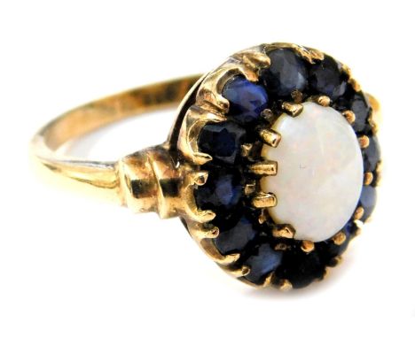 A 9ct gold opal and sapphire ring, the opal in a surround of twelve sapphires, in a two tiered claw setting, size O, 3.9g.