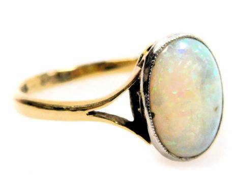 An oval opal solitaire ring, set in white and yellow metal, stamped 18ct and plat, size R, 3.2g.