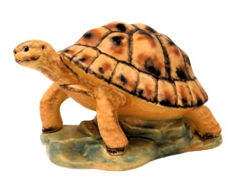A Goebel pottery figure of a tortoise, raised on a rocky base, number 35 104 21, impressed and printed marks, 37cm wide.
