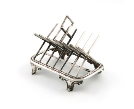 A Victorian silver seven-bar toast rack, by George Fox, London 1865, modelled as saltire bars, central carrying handle, on a 