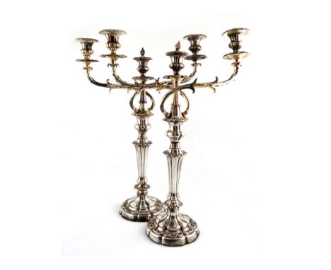 A pair of early 19th century old Sheffield plated three-light candelabra, unmarked, circa 1830, tapering lobed circular colum