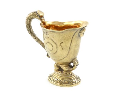 After David Willaume, a Victorian cast silver-gilt cream jug, by Robert Garrard, London 1877, shell form, the scroll handle w