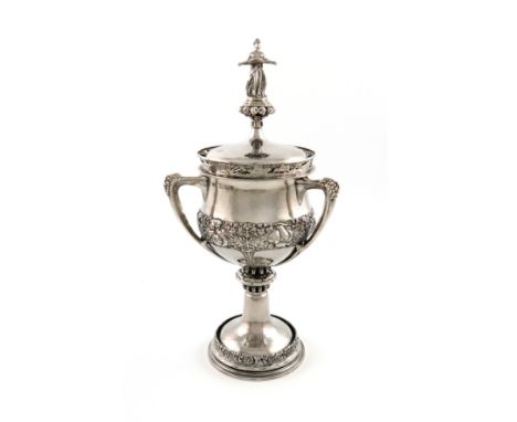 By Alwyn Carr, an Arts and Crafts silver three-handled cup and cover, London 1921, the circular bellied body spot-hammered an