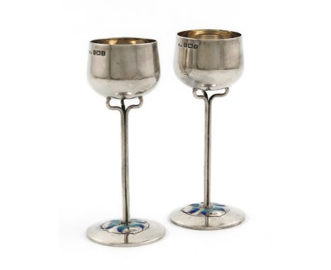 By James Fenton, a pair of Edwardian silver and enamel tot cups, Birmingham 1906, circular bowls, slender stems on raised cir