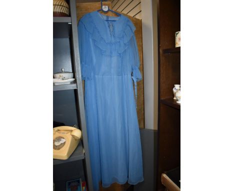 A vintage 1970s pale blue maxi dress, having belt and ruffled cuffs.