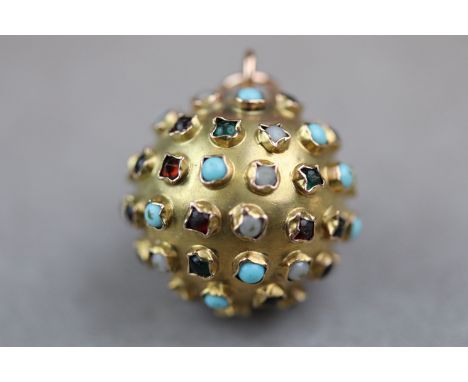 A gem set yellow metal circular 'ball' pendant assessed as 18ct yellow gold, bezel set ruby, white opal, garnet, turquoise, a