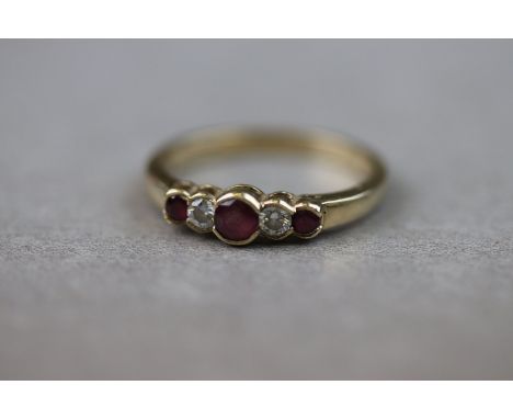 A ruby and diamond five stone 9ct yellow gold dress ring, three alternate graduated round mixed cut rubies with two small rou